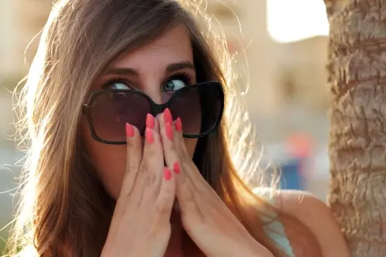 Personne appliquant une bande de cire sur la lèvre supérieure devant un miroir