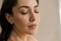 Gros plan sur le contour de l'œil d'un visage adulte au repos, lumière douce, peau naturelle