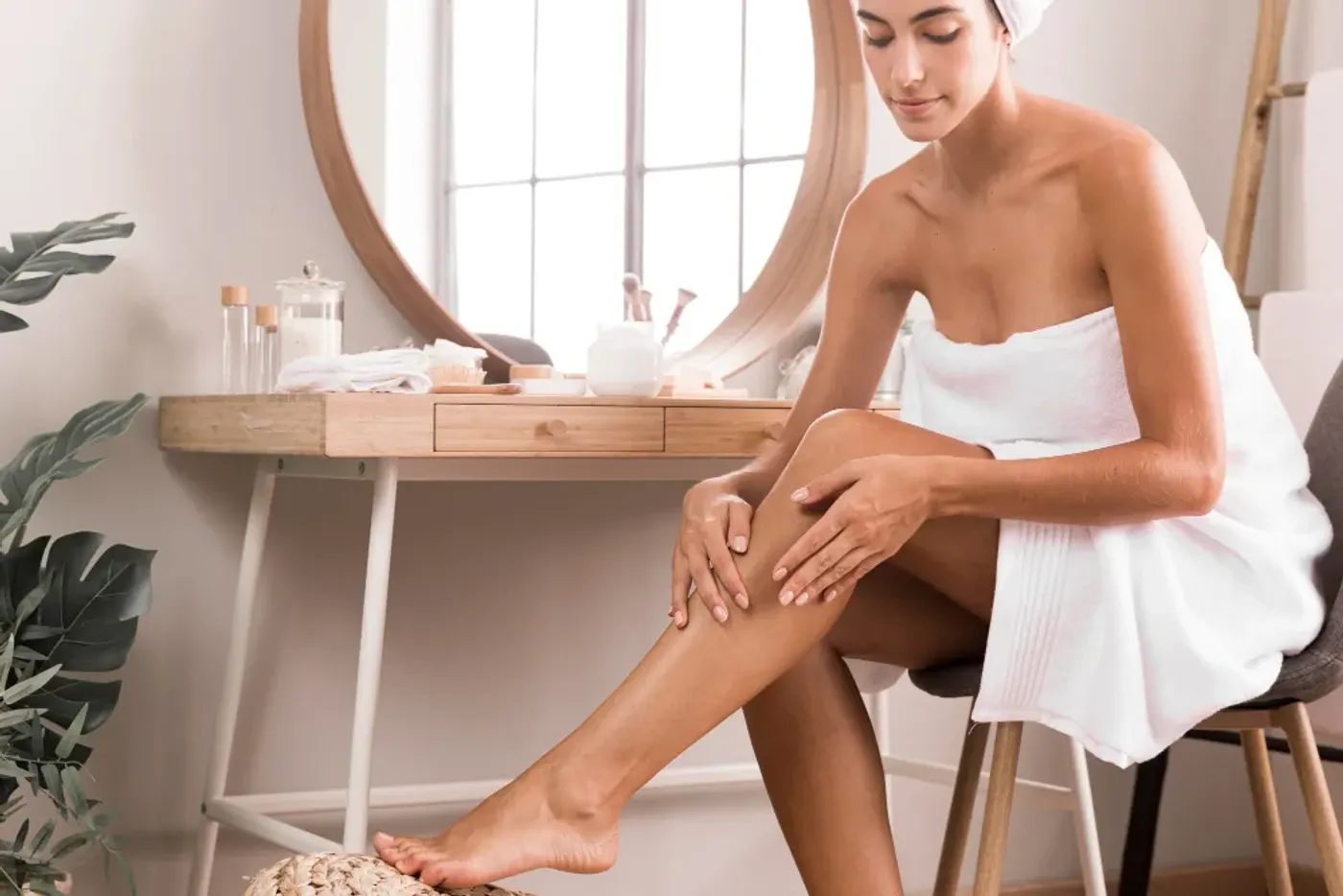 Jambe en cours de rasage avec un rasoir manuel et une mousse blanche dans une salle de bain