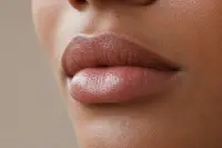 Lèvres brillantes avec un gloss transparent, texture naturelle, lumière douce