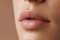 Gros plan sur des lèvres nues au contour naturel, lumière douce, peau non retouchée