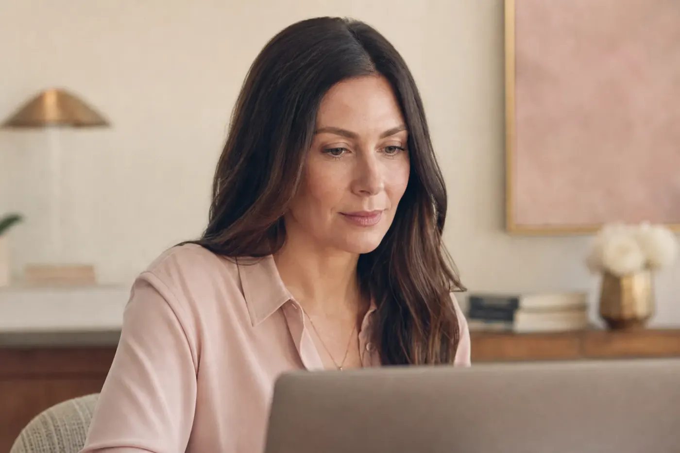 Femme adulte de face devant un ordinateur portable, lumière douce de face, maquillage discret et net