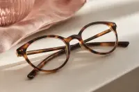 Paire de lunettes de vue posée sur une surface claire, lumière naturelle douce