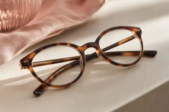 Paire de lunettes de vue posée sur une surface claire, lumière naturelle douce