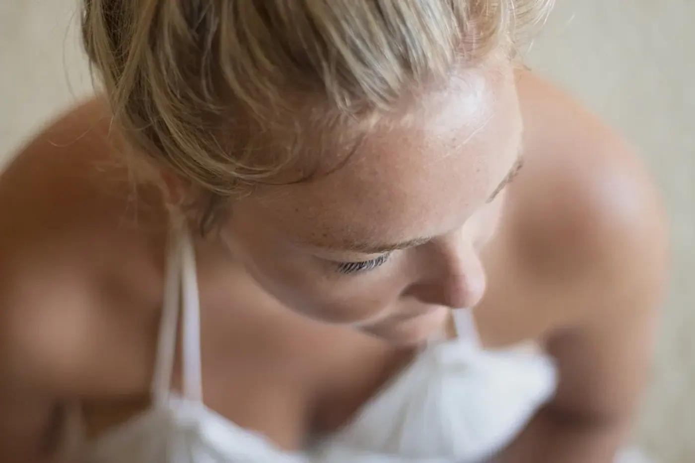 Gros plan d’une personne appliquant un soin visage sur la zone du nez et du menton