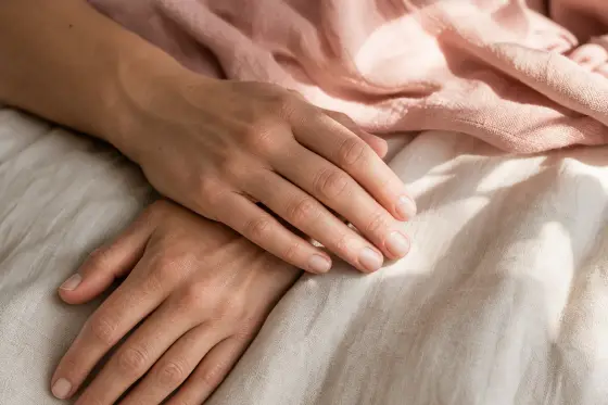 Mains posées sur une surface claire avec des ongles courts et nets, lumière d'été