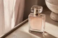 Flacon de parfum posé sur une surface claire, lumière douce, composition sobre