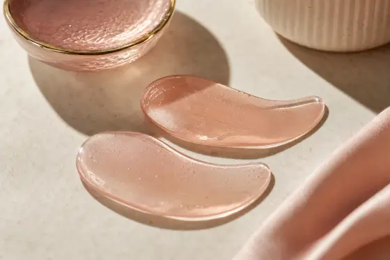 Patchs anti-cernes hydrogel posés sur une surface claire, lumière naturelle douce