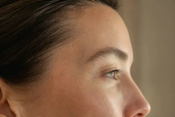 Profil d’un visage au repos, tempe légèrement creusée visible, lumière douce latérale