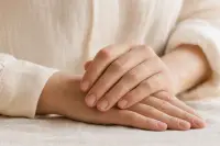 Mains posées sur une surface claire, ongles courts et naturels, lumière douce