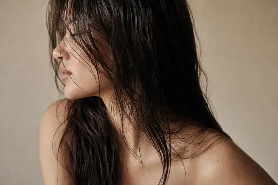 Cheveux mouillés et brillants après rinçage, mèches lisses captant la lumière naturelle